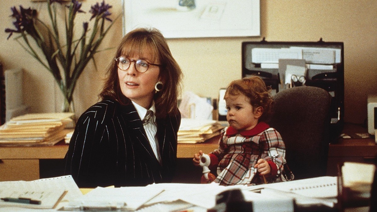 Une femme et un enfant sont assis dans un bureau du Baby Boom.