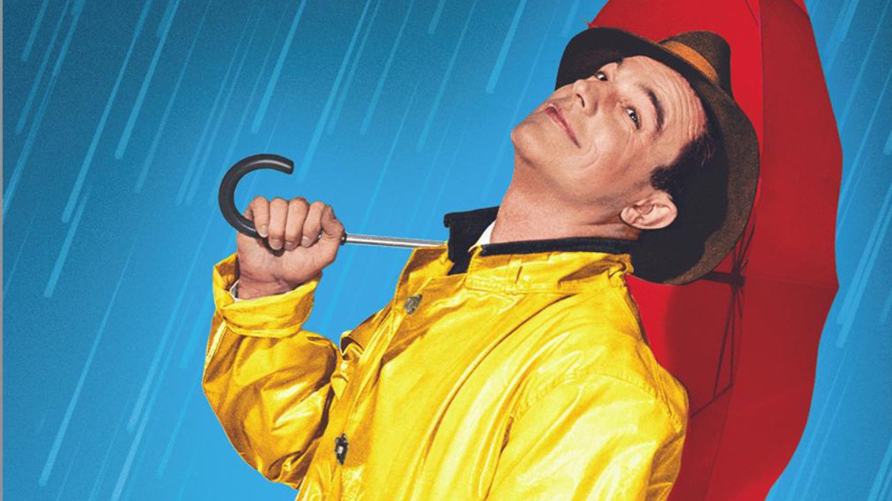 Gene Kelly as Don Lockwood smiling while holding an umbrella in Singin' in the Rain.