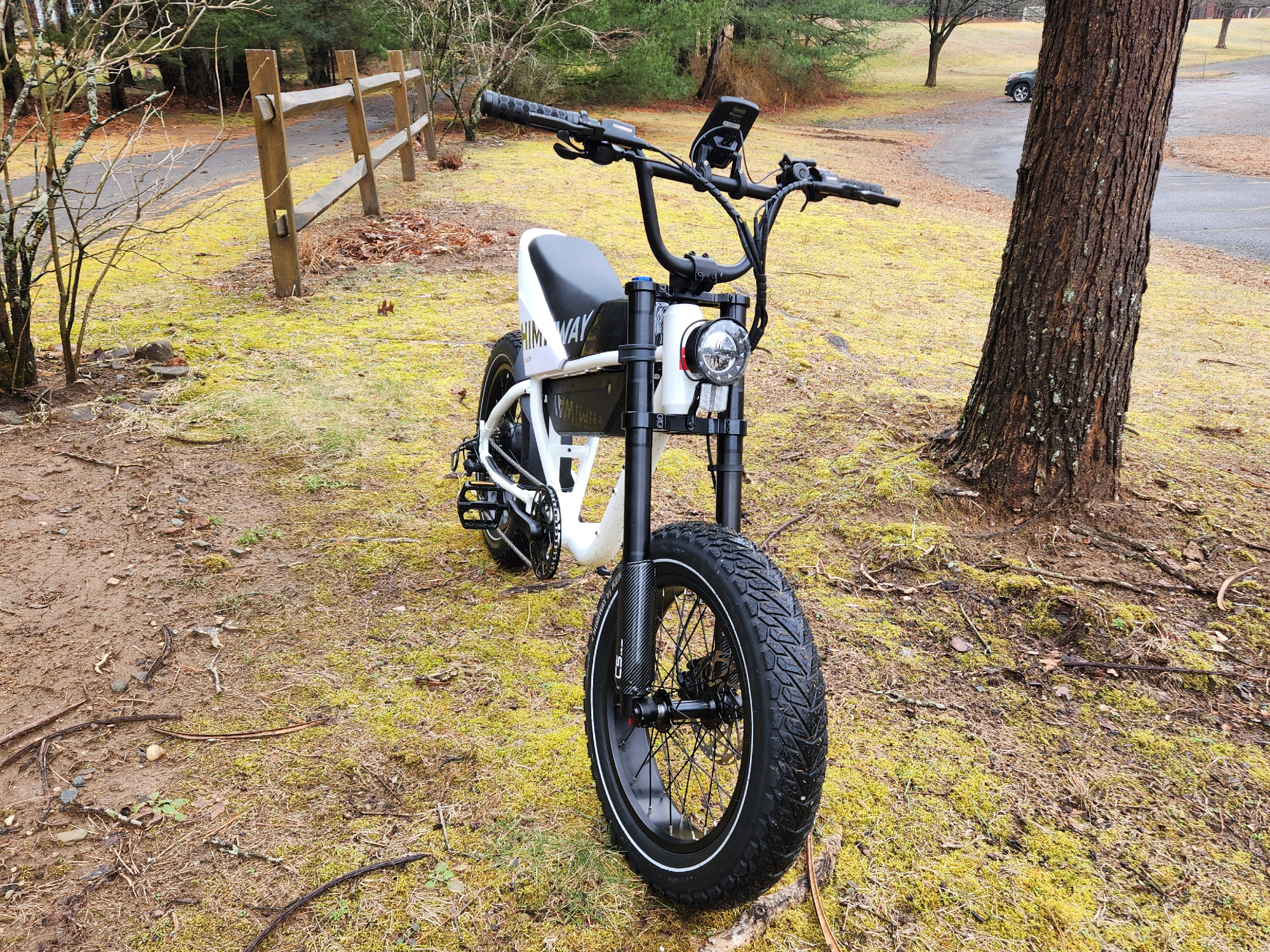 Vélo électrique Himiway C5 côté droit, vue de trois quarts du vélo garé sur un terrain à côté d'un parking.