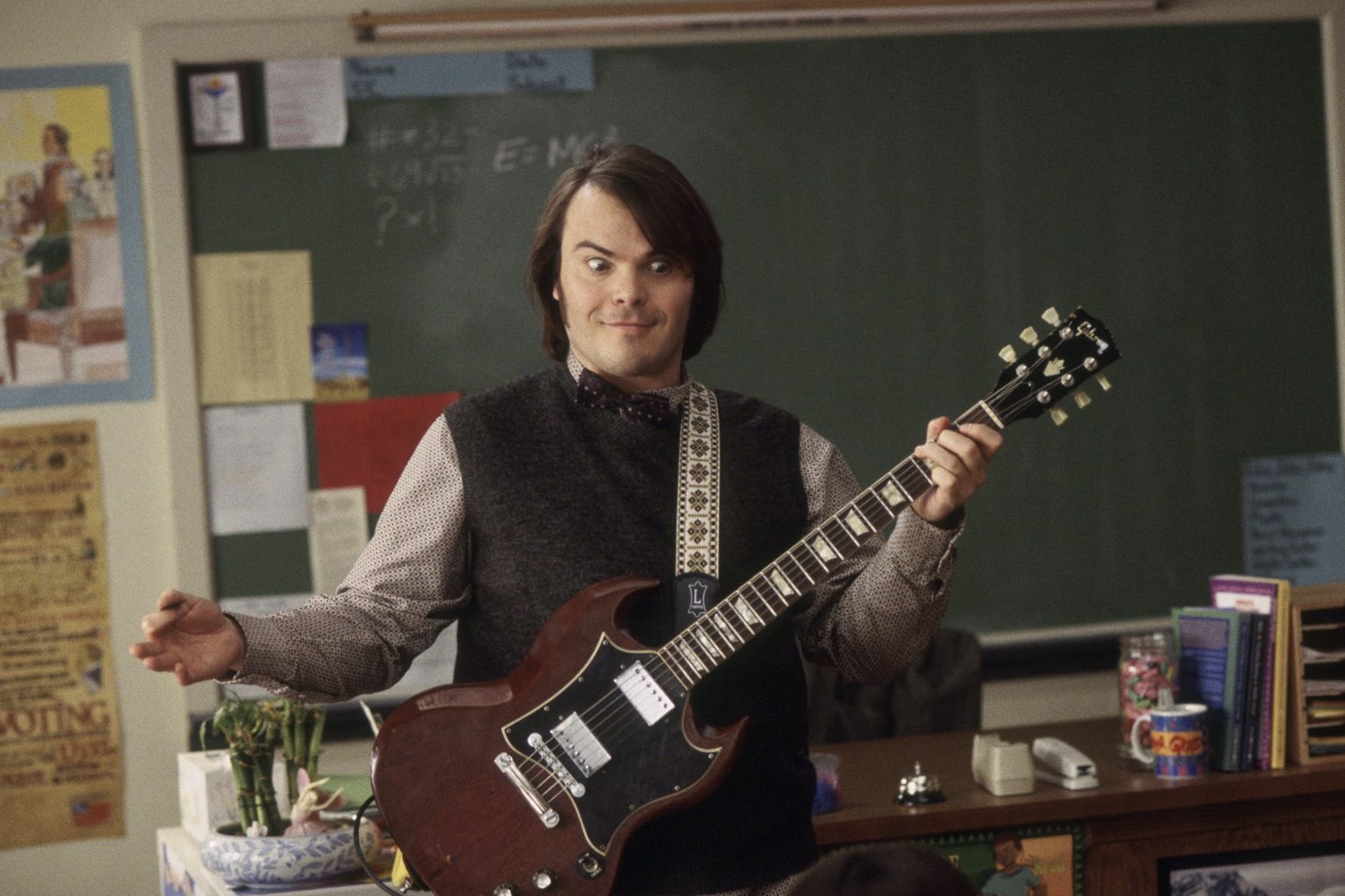 Jack Black tient une guitare devant la salle.