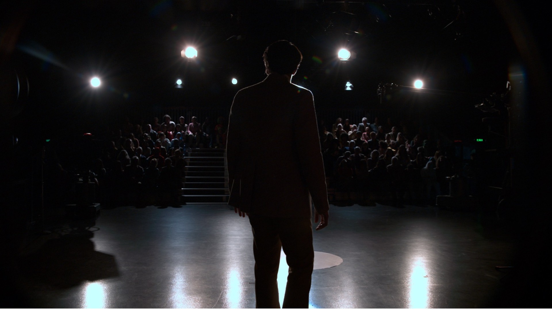 David Dastmalchian steht seinem Talkshow-Publikum in einem Standbild aus „Late Night with the Devil“ gegenüber