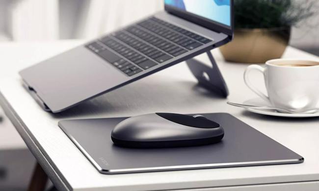 The Satechi M1 Wireless Mouse on a desk next to a MacBook.