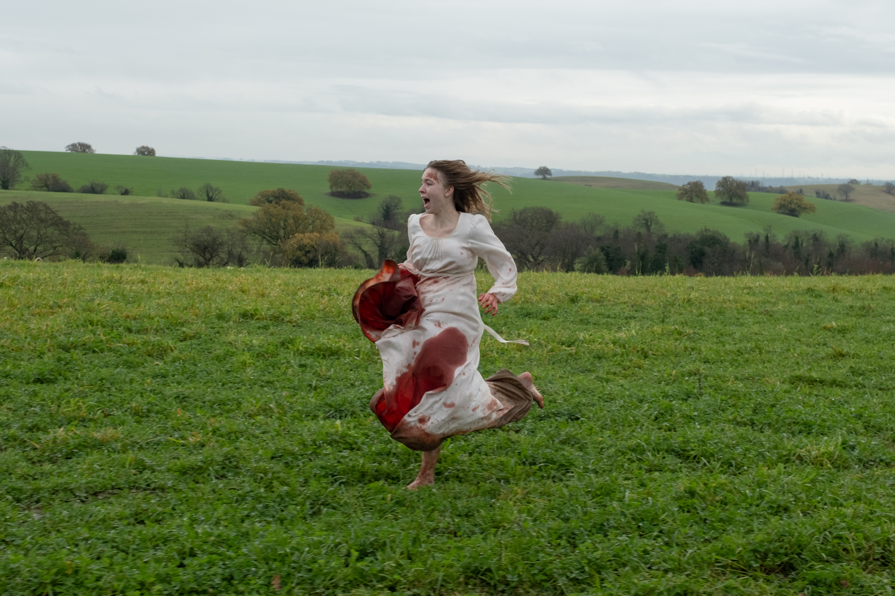 Sydney Sweeney corre por um campo com um vestido ensanguentado em Imaculada.