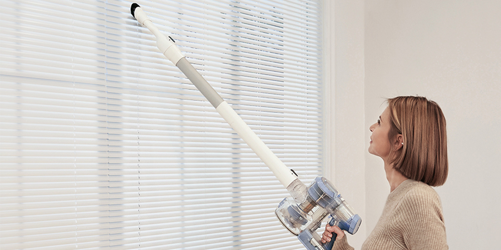 Une femme utilisant l'aspirateur sans fil Tineco.