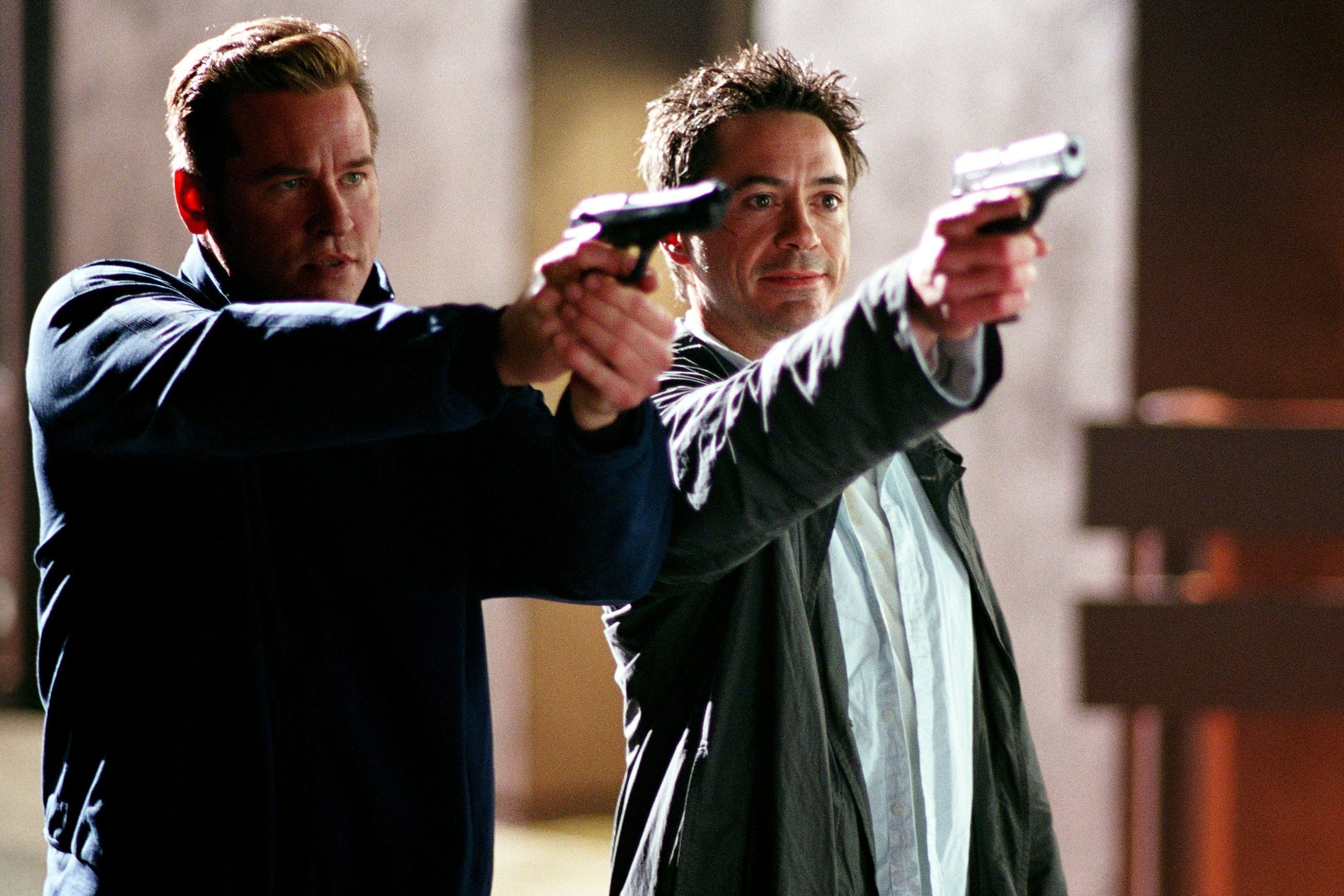 Val Kilmer e Robert Downey Jr. apontam armas juntos em Kiss Kiss Bang Bang.