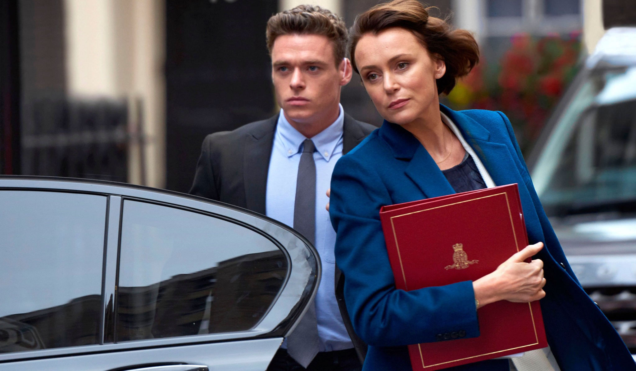 Uma mulher e um homem saem de um carro em Bodyguard.