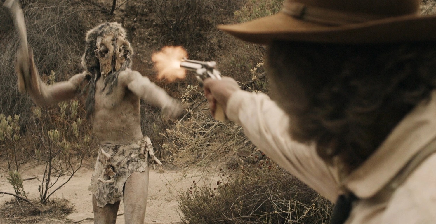 Um homem atira em um monstro em Bone Tomahawk.