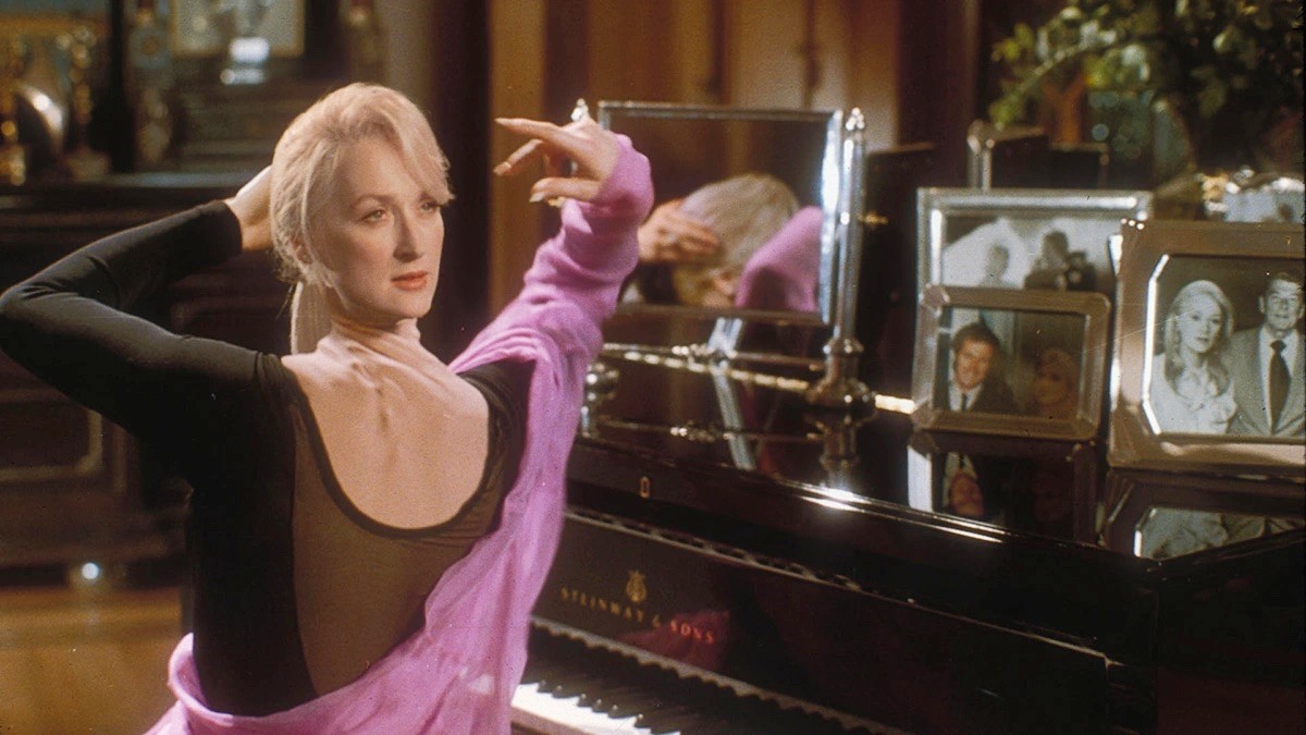 A woman twists her neck at a piano in Death Becomes Her.