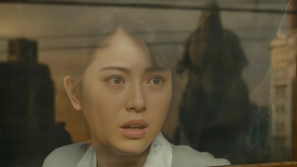 A woman looks at Godzilla through a window in Godzilla Minus One.