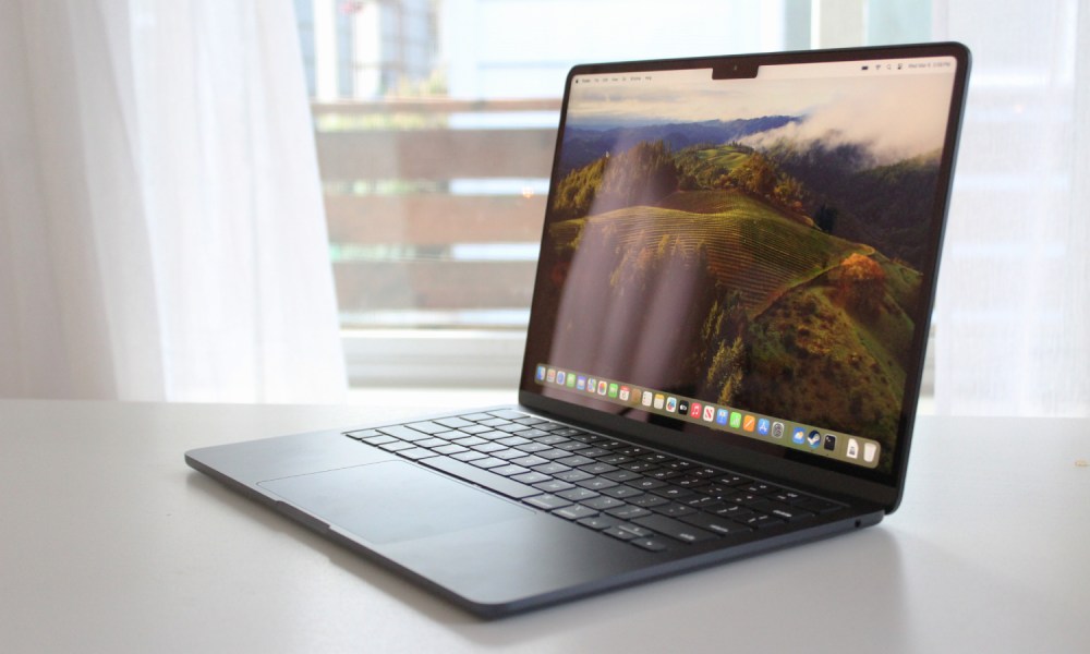 The MacBook Air on a table in front of a window.