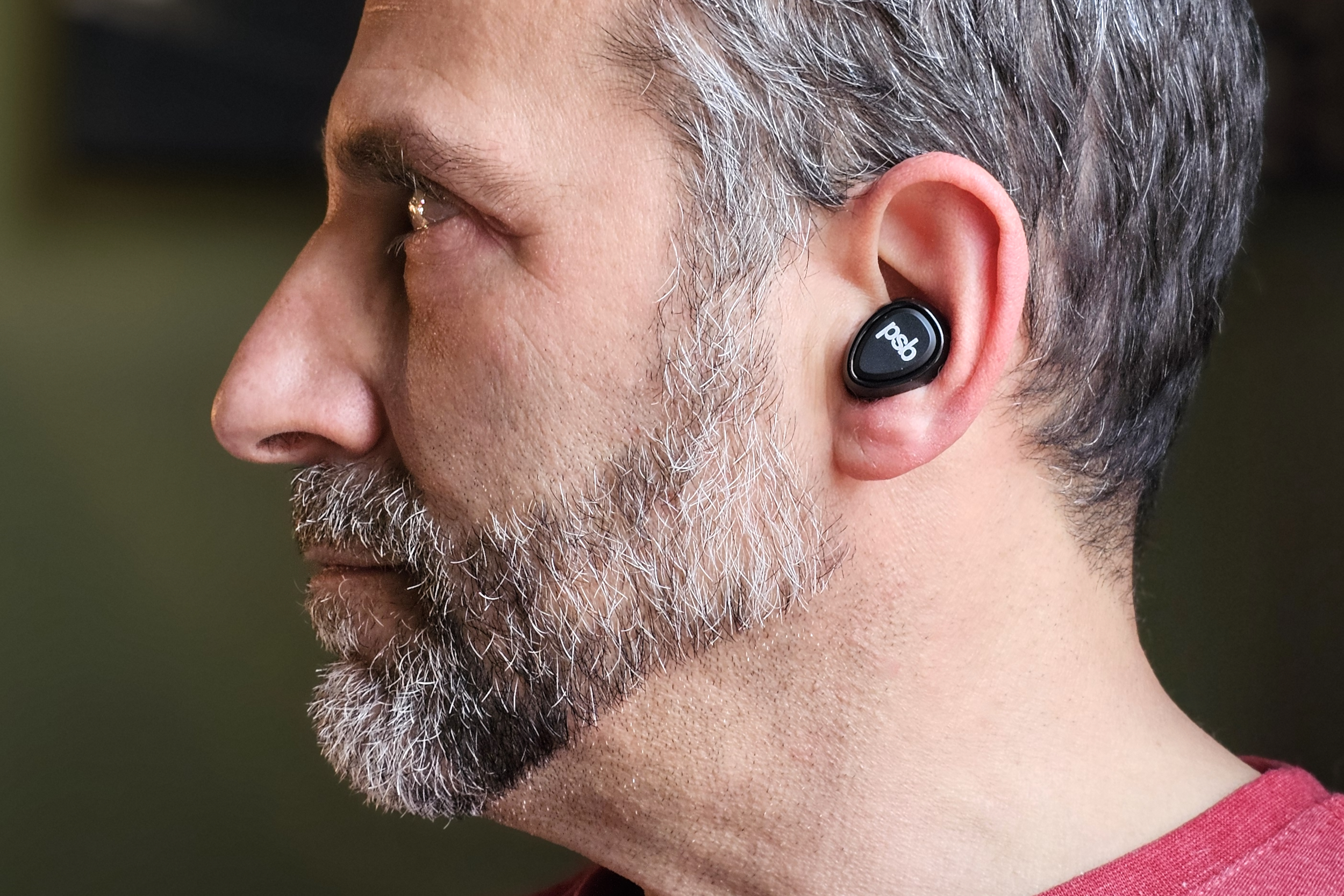 Simon Cohen wearing the PSB Speakers M4U TWM earbuds (side view).