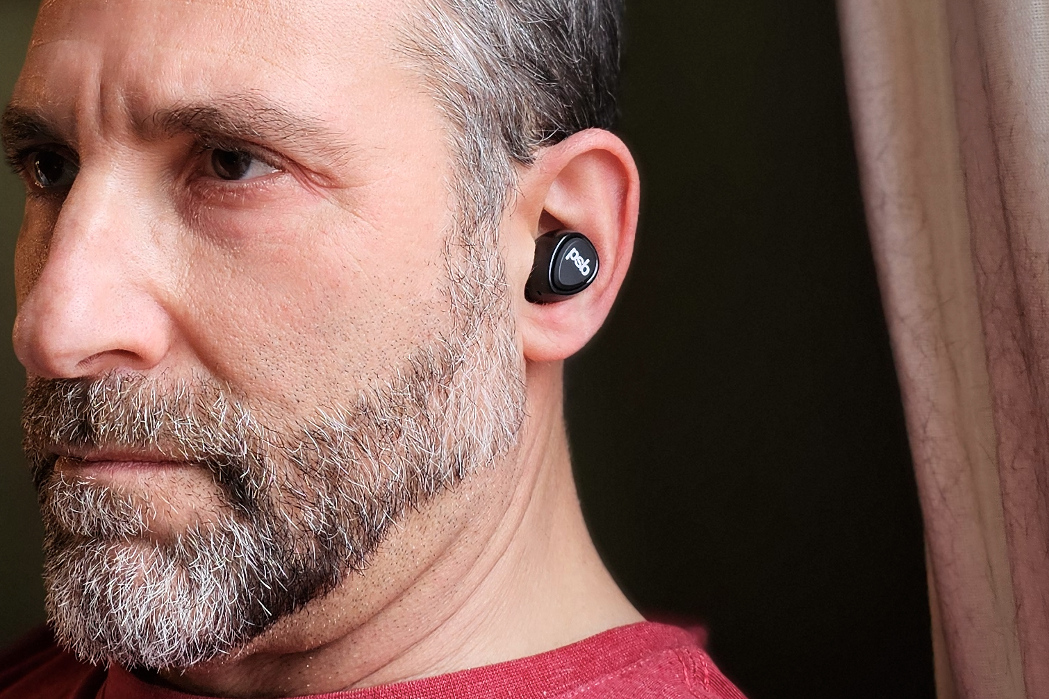 Simon Cohen wearing the PSB Speakers M4U TWM earbuds (front-side view).