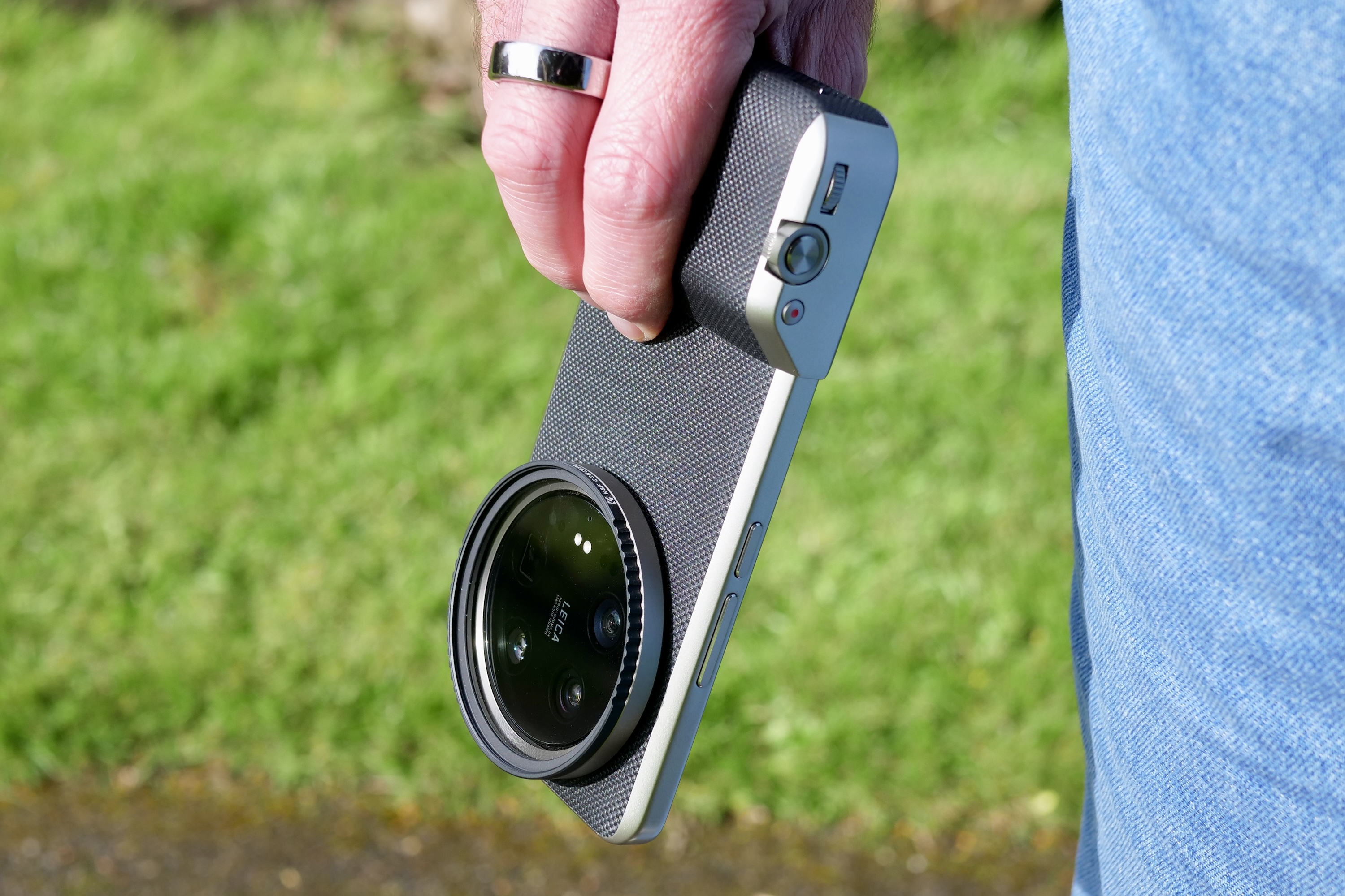 A person holding the Xiaomi 14 Ultra, with the Photography Kit fitted.