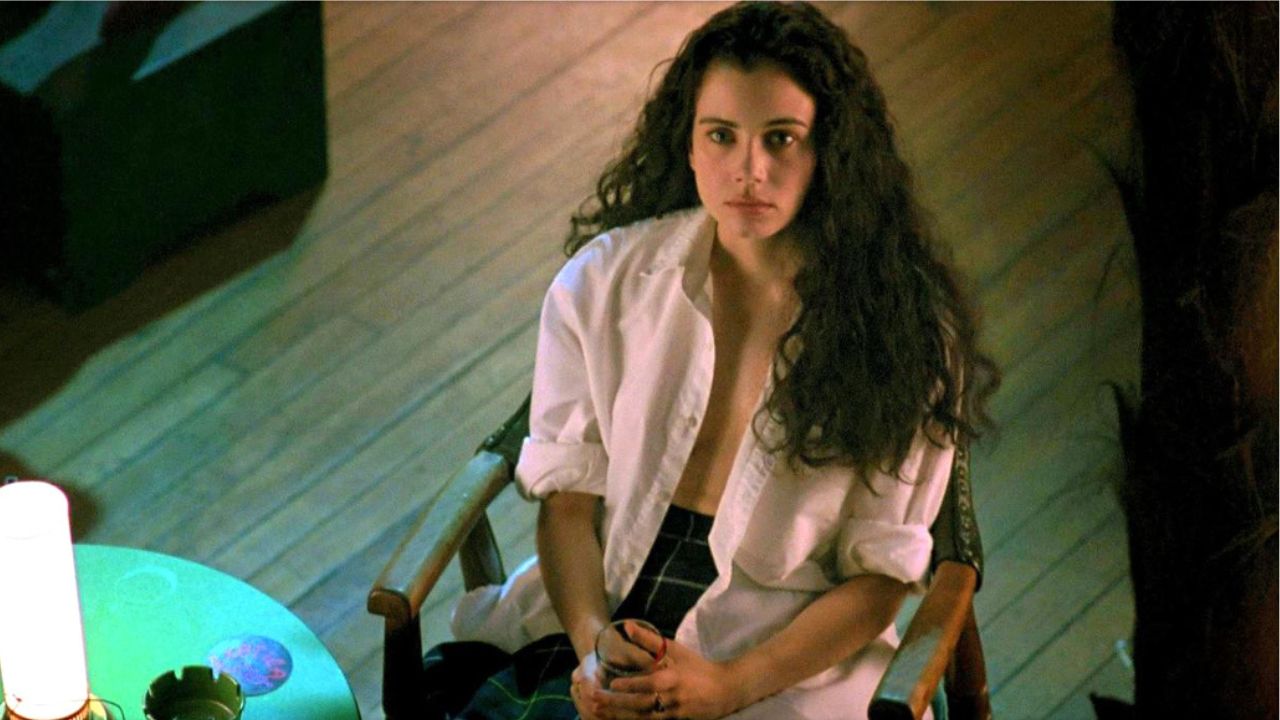 Mia Kirshner como Christina sentada e olhando para cima no filme Exotica.