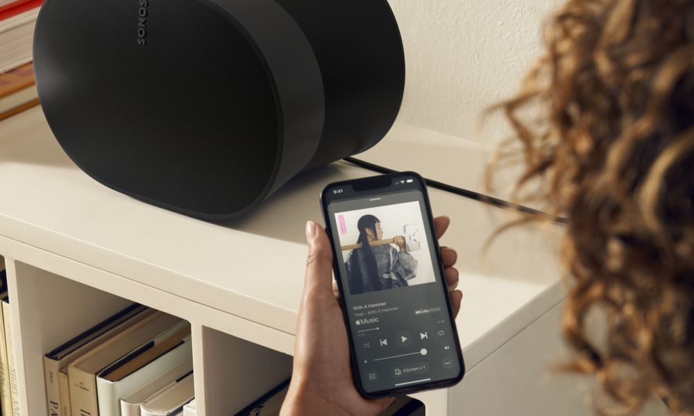 A hand-held iPhone showing the new Sonos app's now-playing screen.