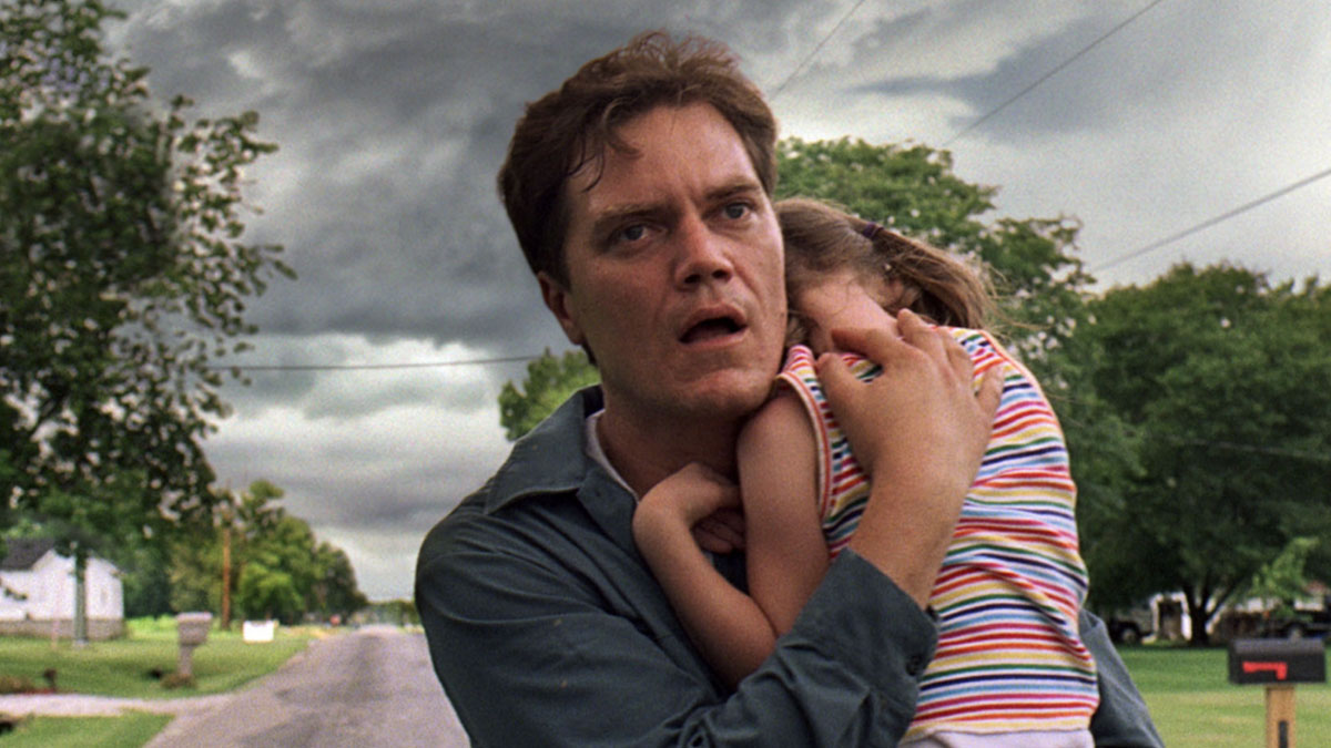 Michael Shannon carrega uma criança em Take Shelter.
