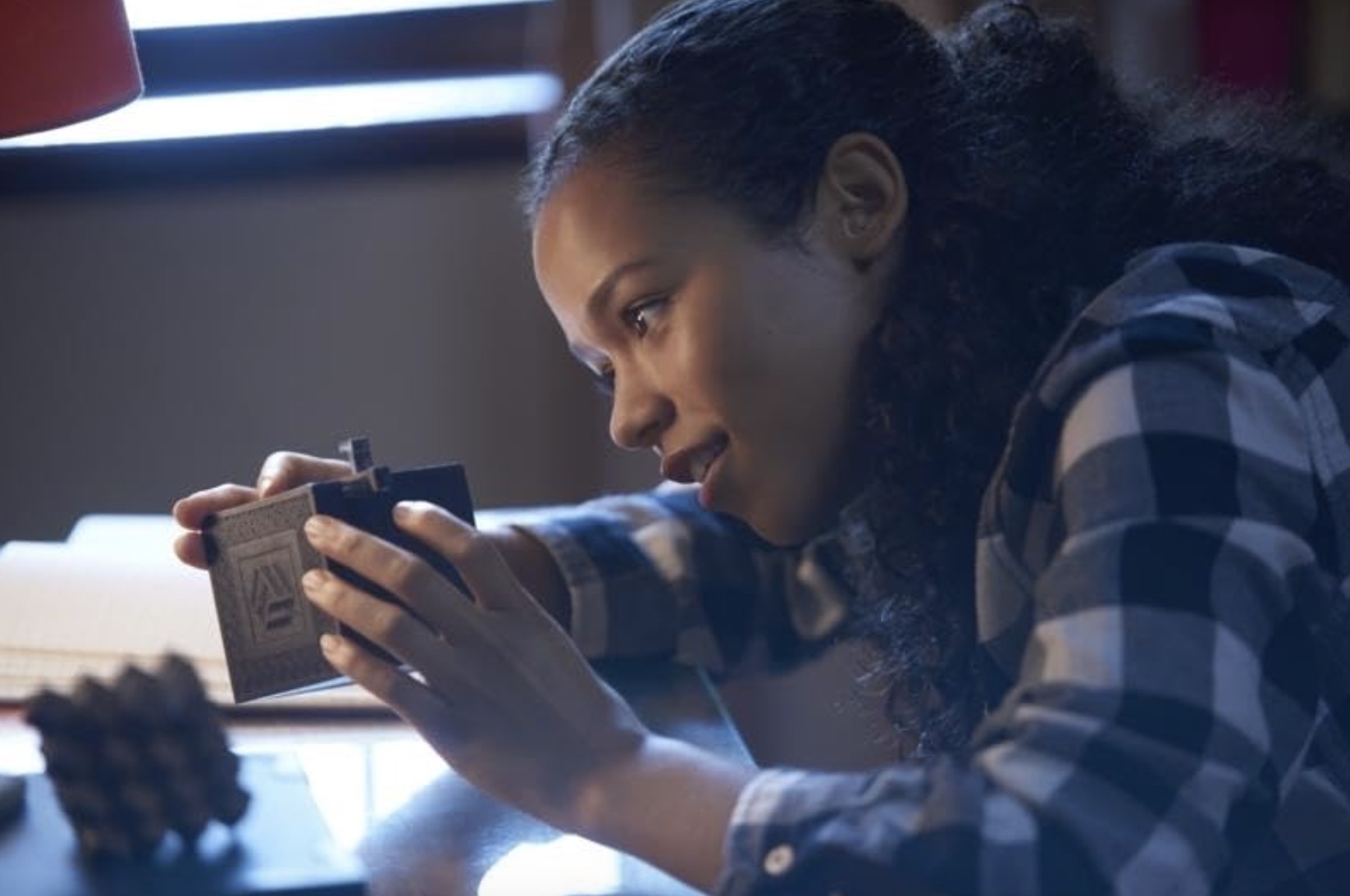 Une fille essaie de résoudre une boîte de puzzle.