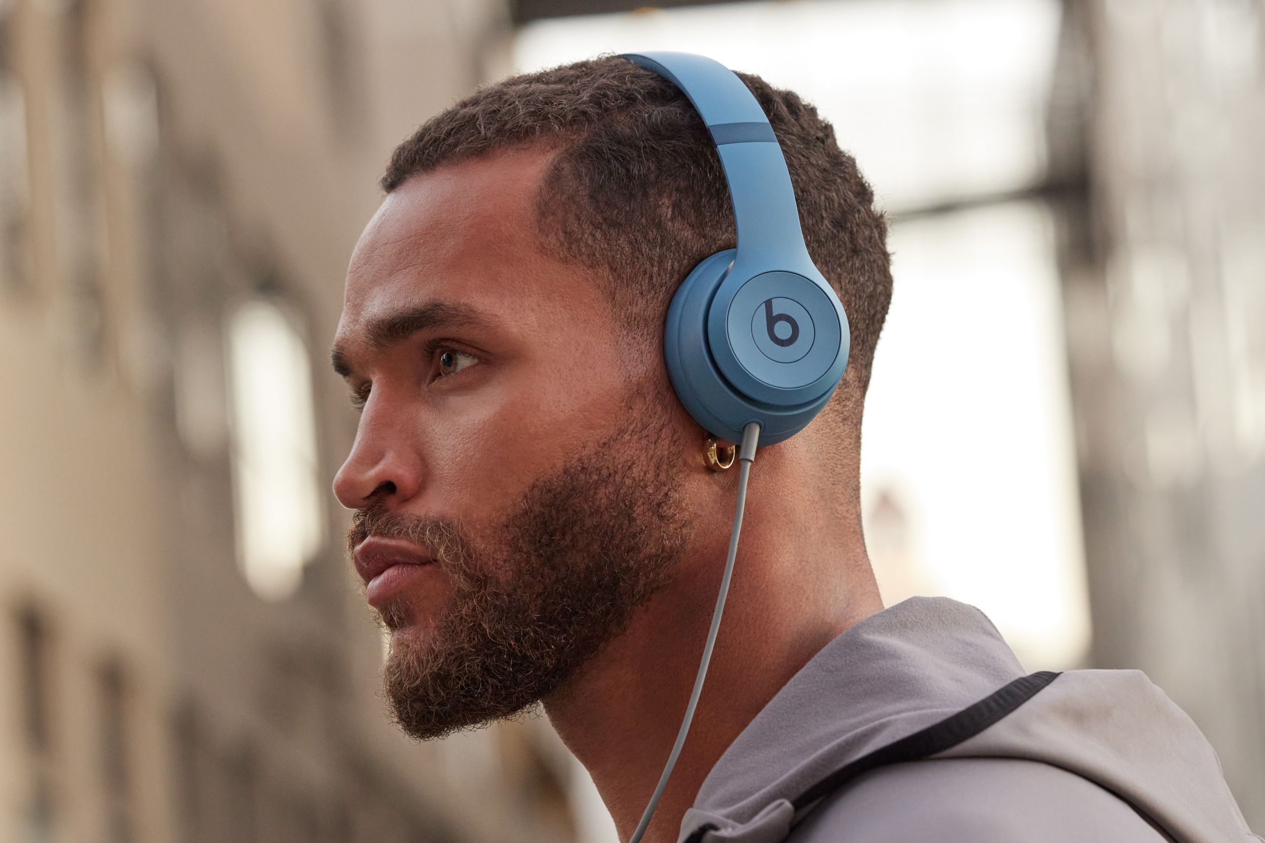 Homme portant un Beats Solo 4 en bleu ardoise.