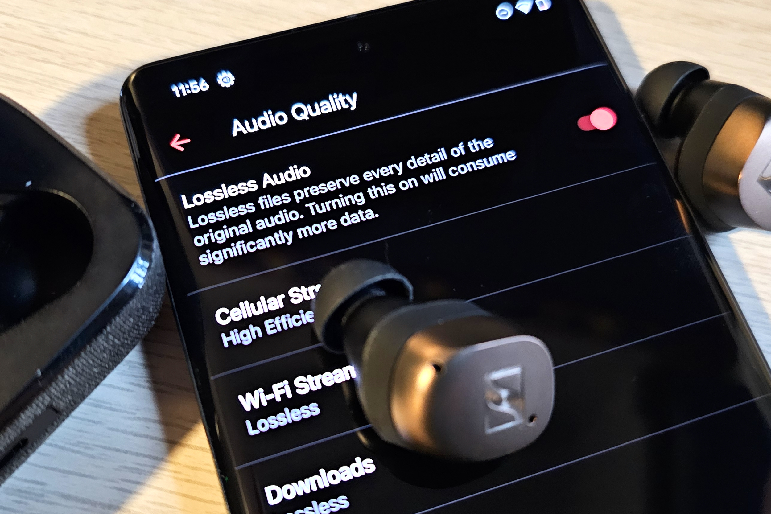 Ein Google Pixel 7 Pro mit verlustfreiem Audio von Apple Music, daneben ein Paar Sennheiser Momentum True Wireless 4-Ohrhörer.