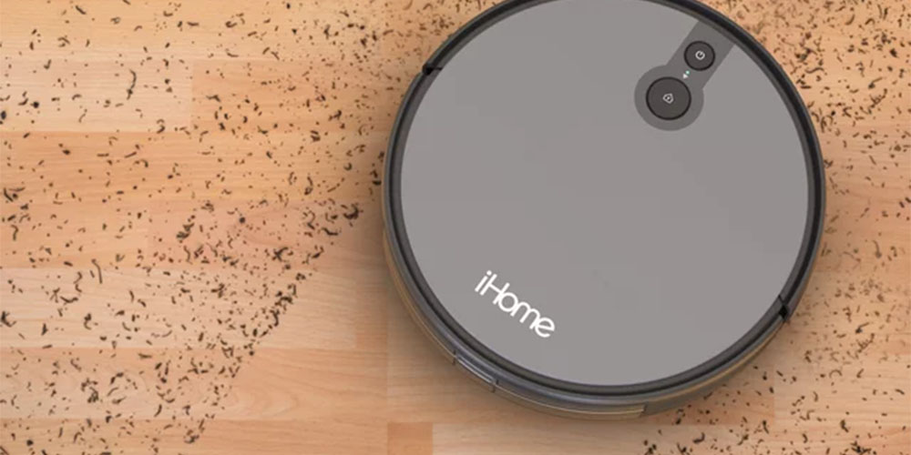 The iHome AutoVac Juno Robot Vacuum sucking up dirt on a hard floor.