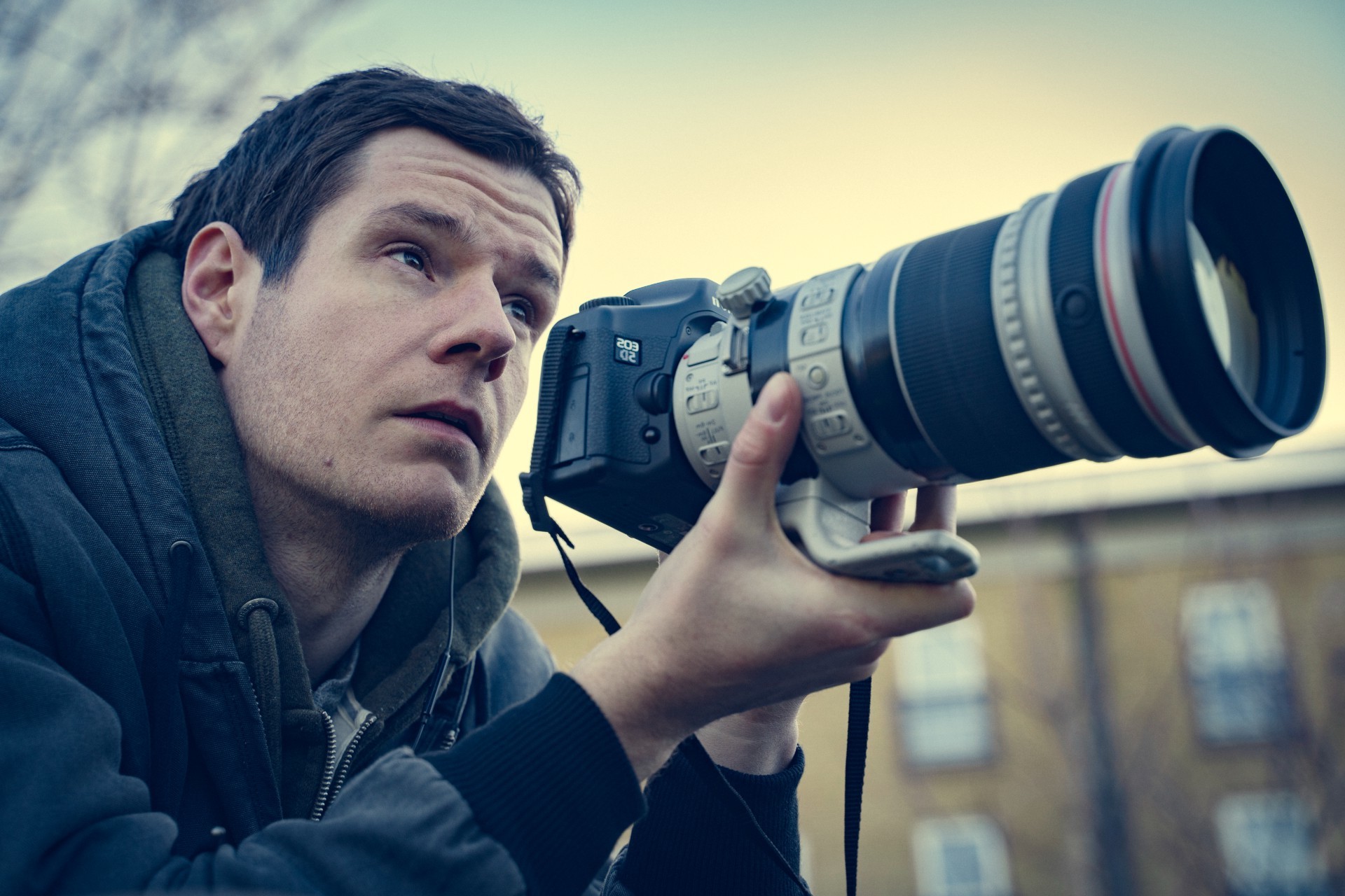 A man aims his camera in Scoop.