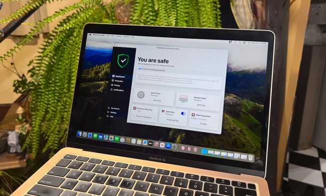 A MacBook Air is shown with the Bitdefender for Mac dashboard open.