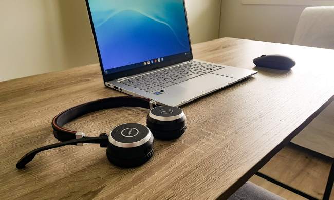 Chromebook on a table with a mouse and headphones