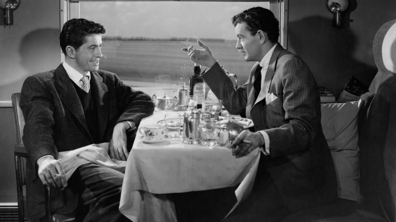 Farley Granger and Robert Walker as Guy and Bruno talking on a train in Strangers on a Train