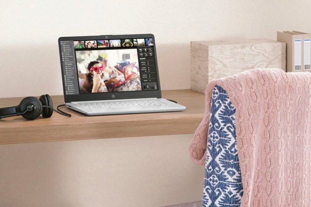 The HP 14-inch laptop on a small desk with some headphones.