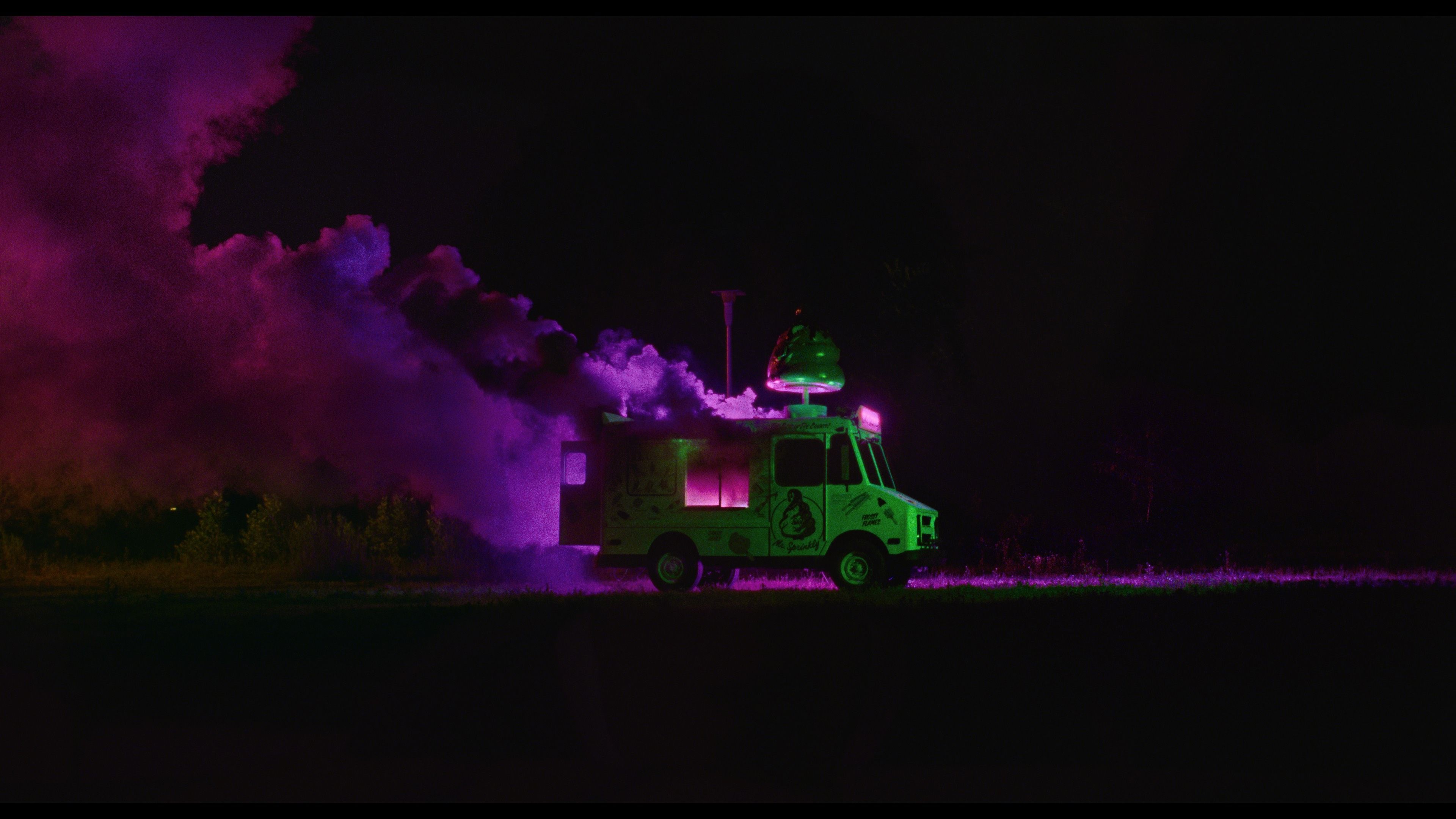 Eerie pink smoke billows from a green ice-cream truck in a still from I Saw the TV Glow.