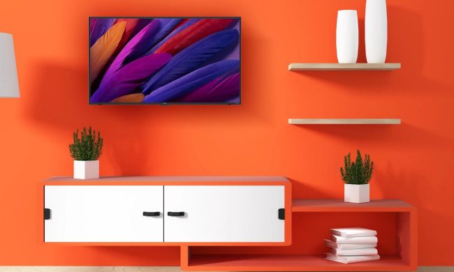 The Onn. 43-inch Class 4K LED Roku Smart TV on an orange wall.
