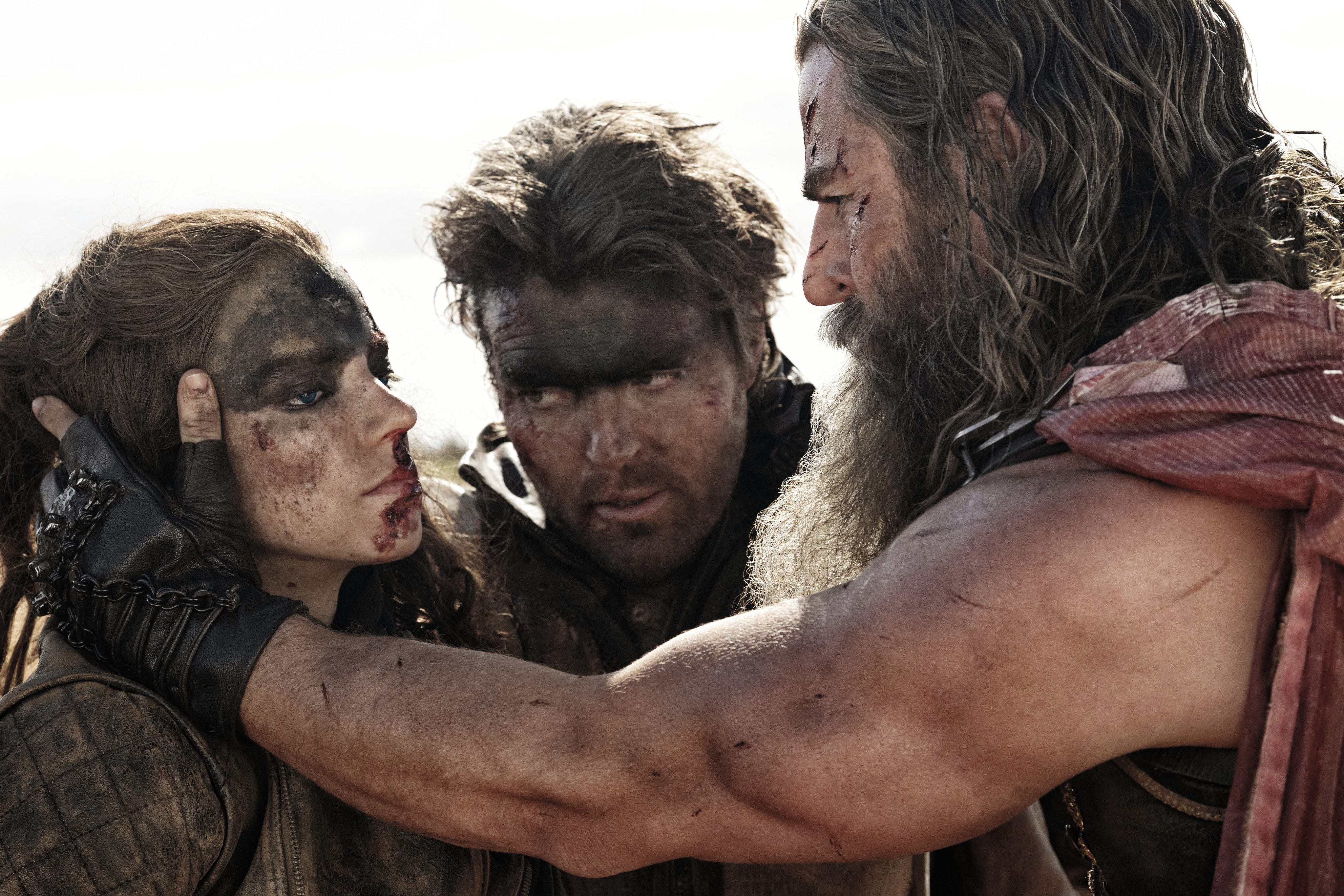 Tom Burke fica entre Anya Taylor-Joy e Chris Hemsworth em Furiosa: A Mad Max Saga.