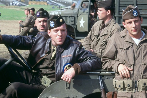 Four men in a vehicle wearing army uniforms from World War II in a scene from Band of Brothers.