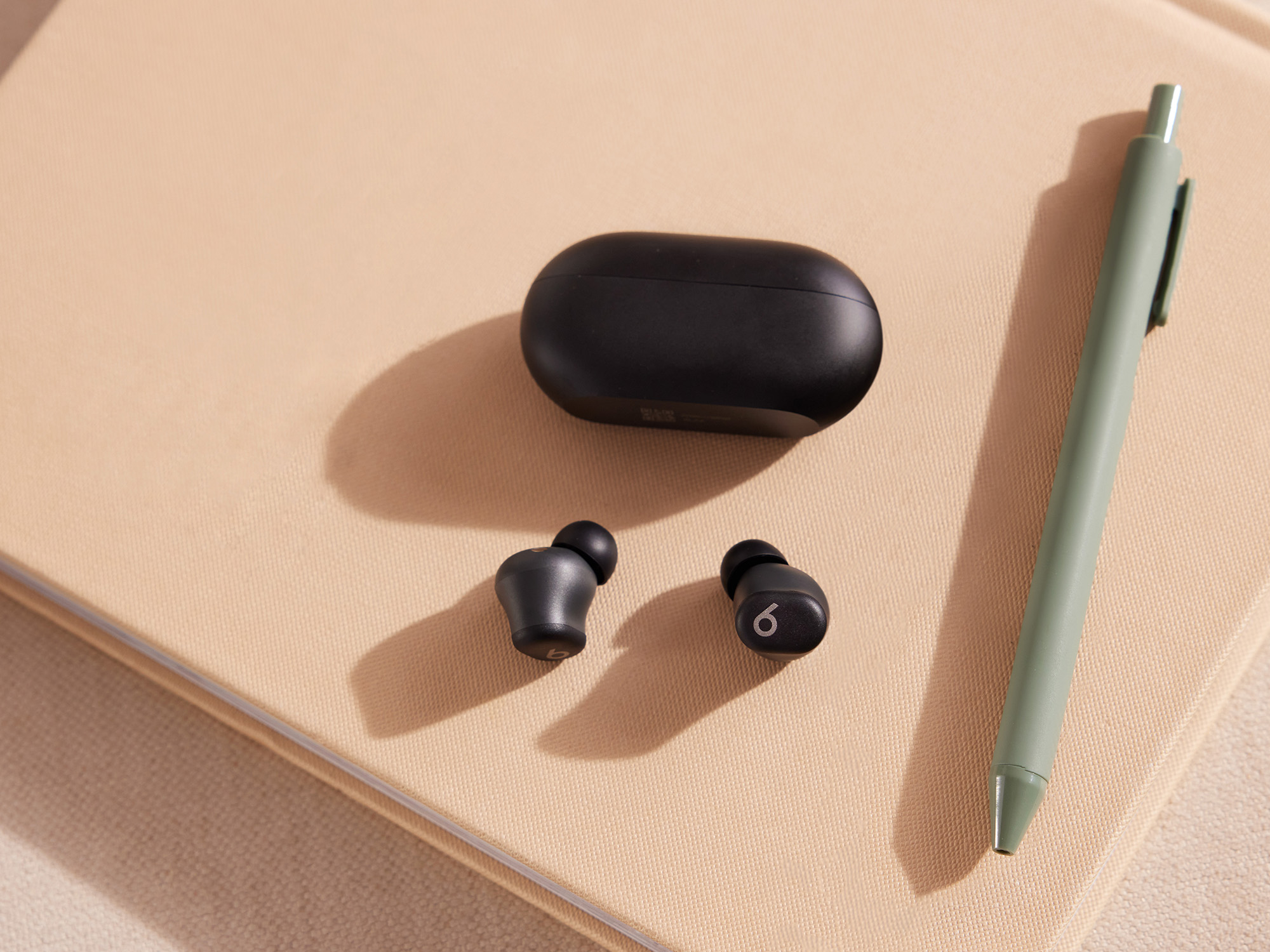 Os Beats Solo Buds em preto, junto com o estojo de carregamento.