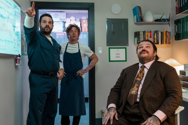 Three men stand and sit in an office in The Bear season 3.