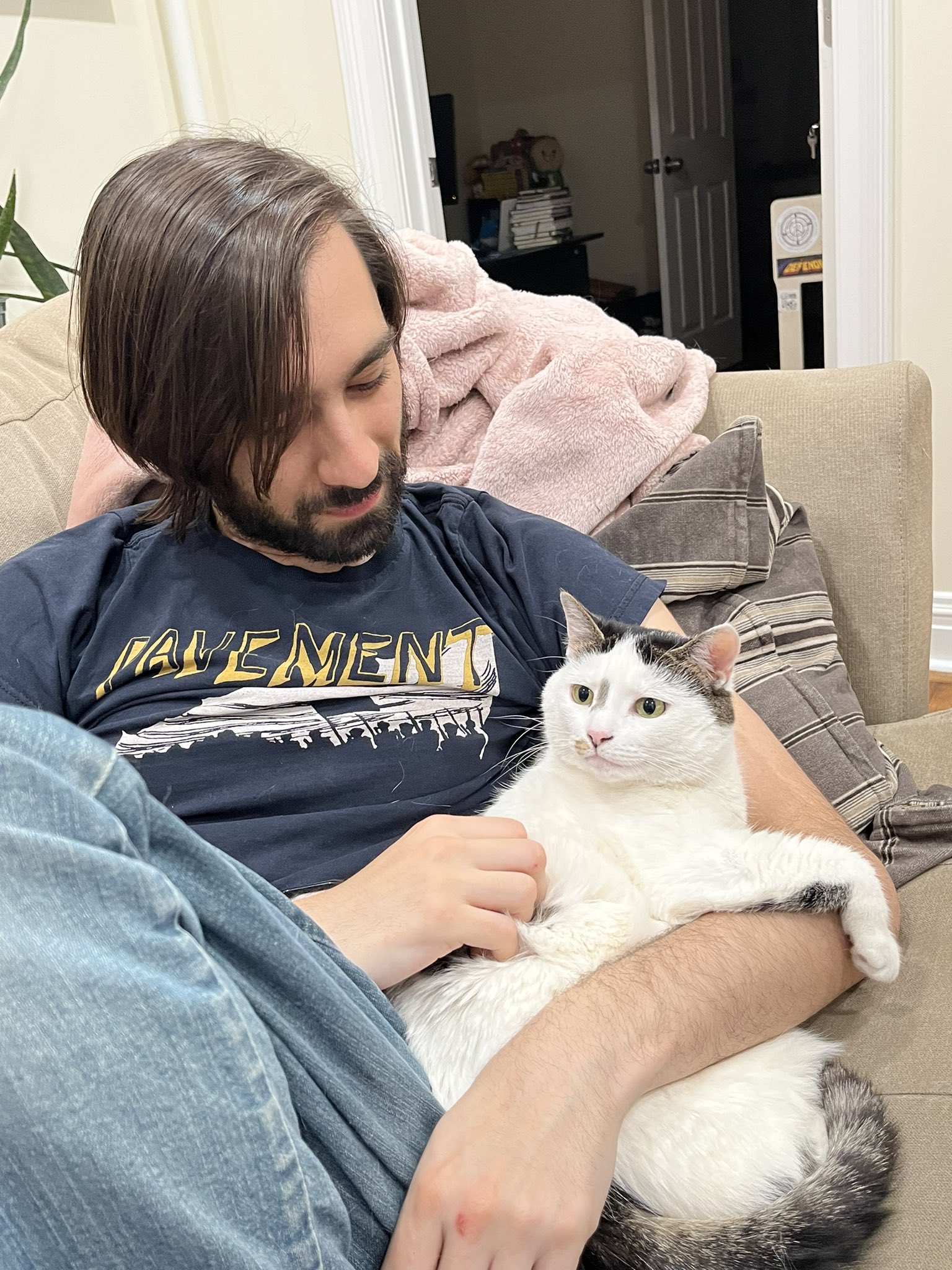 A man holds a white cat.