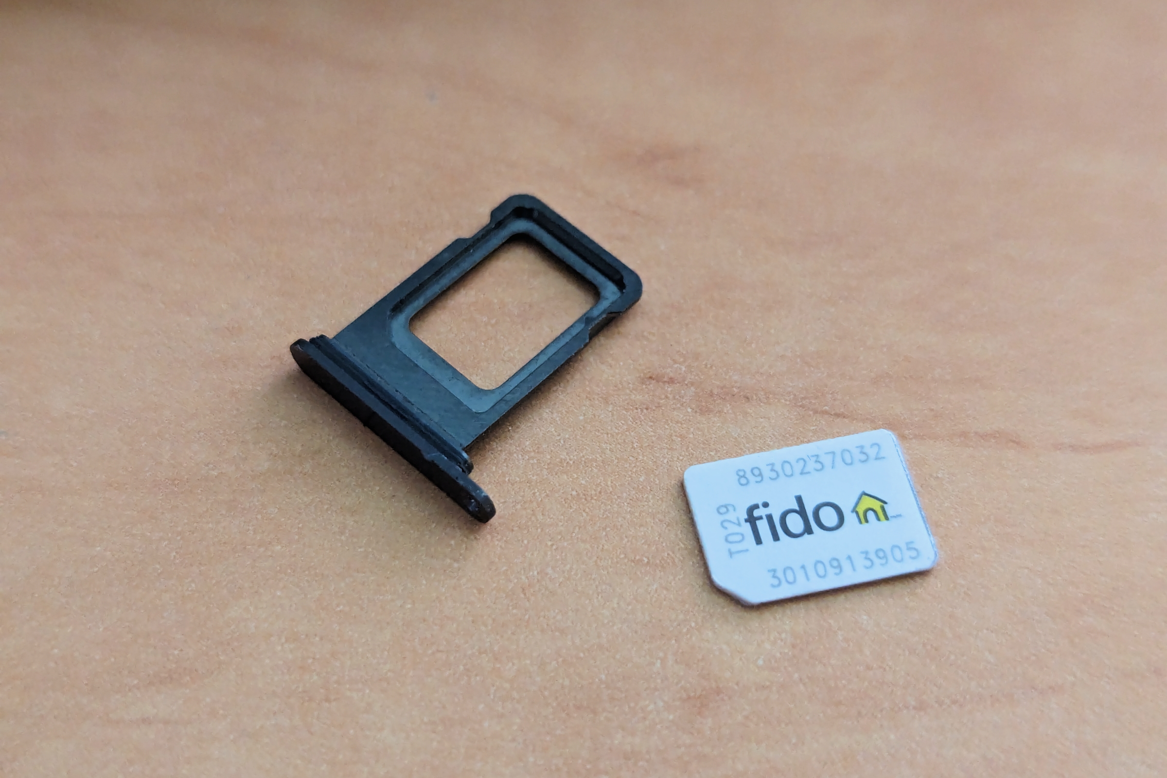SIM card tray and nano-SIM card from an iPhone 14 Pro Max.