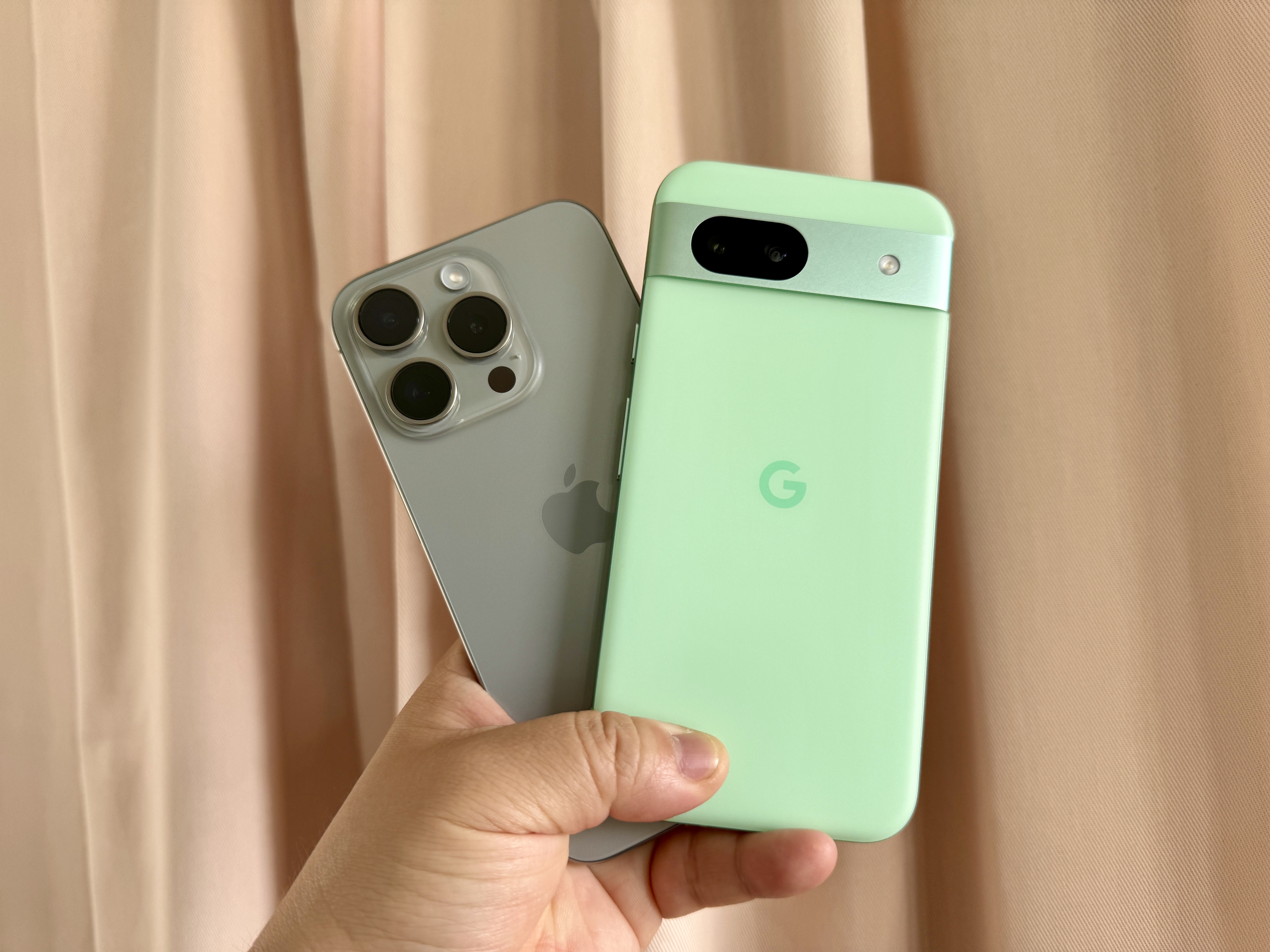 iPhone 15 Pro (izquierda) y Google Pixel 8a en la mano.