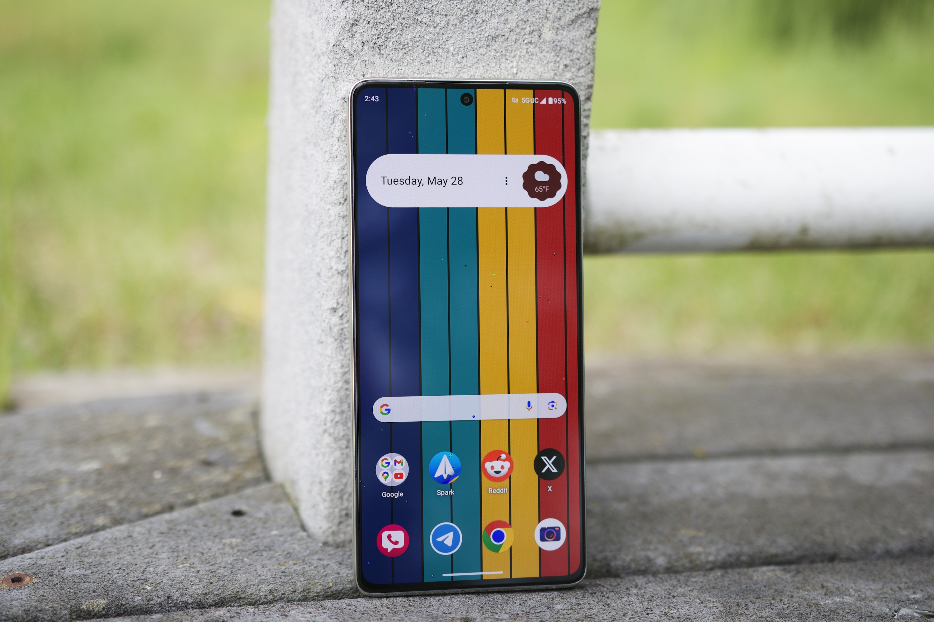 Moto G Stylus 5G (2024 г.) стоит вертикально в парке на улице.