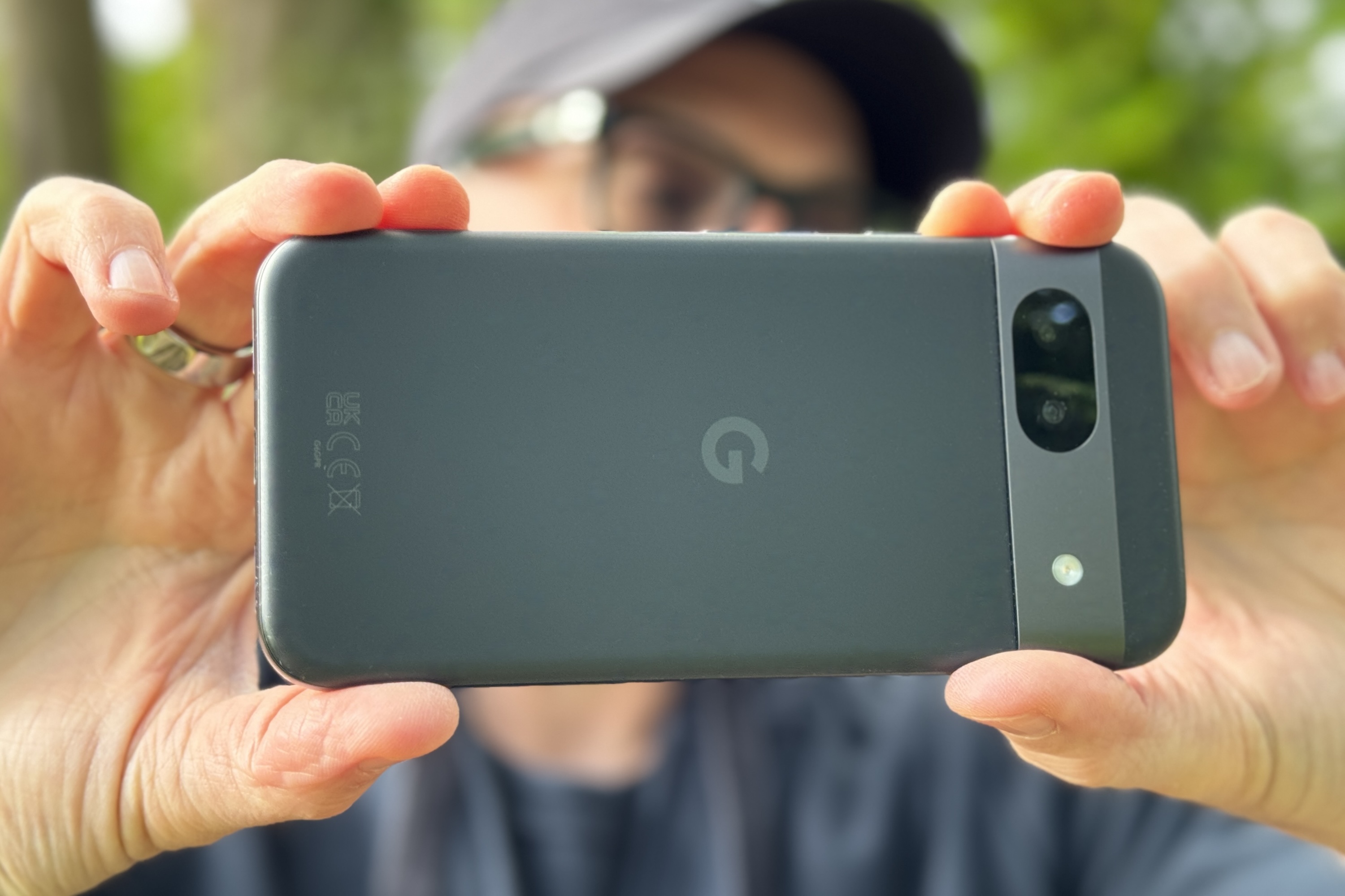 A person taking a photo with the Google Pixel 8a.