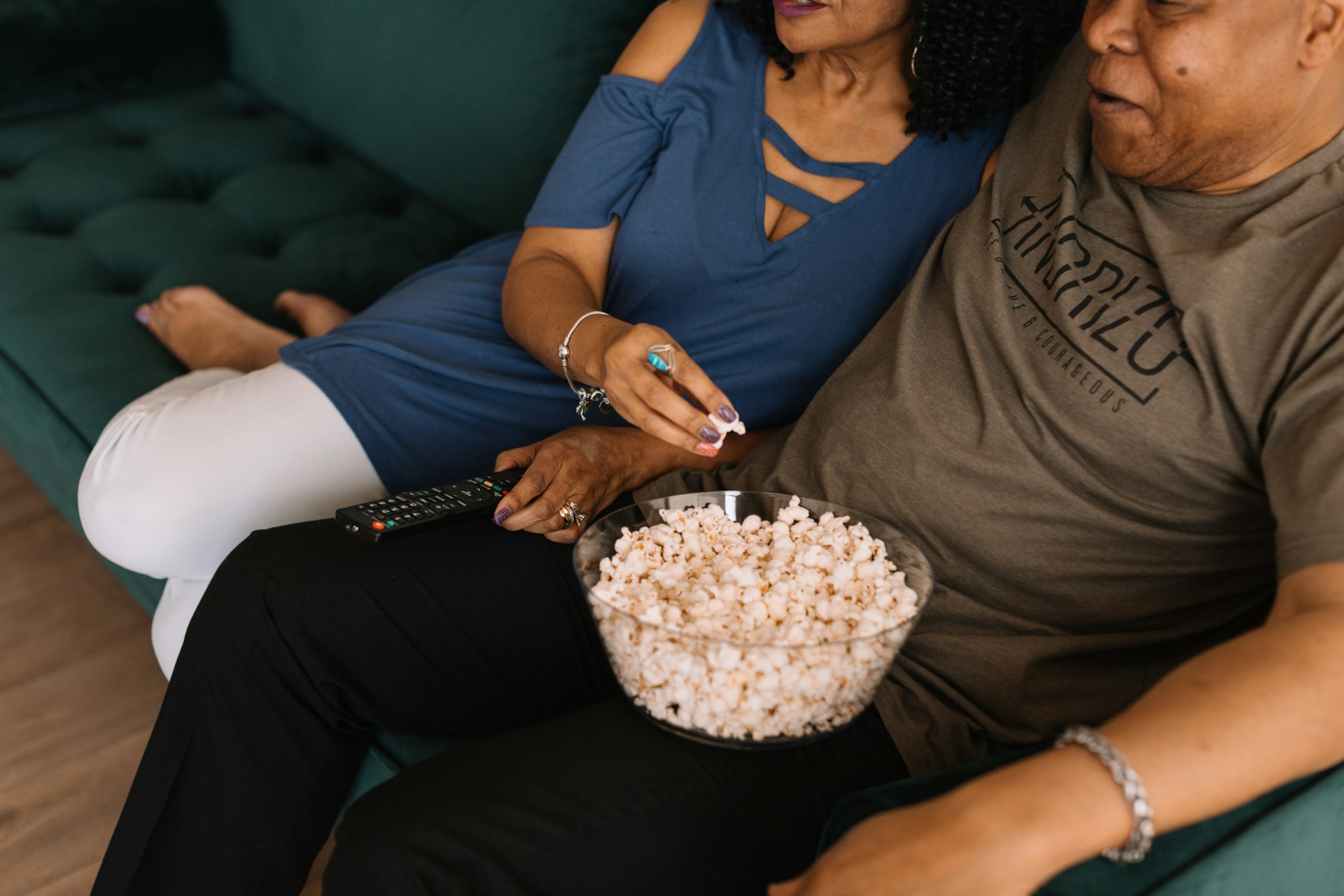 Un couple mange du pop-corn en regardant la télévision.