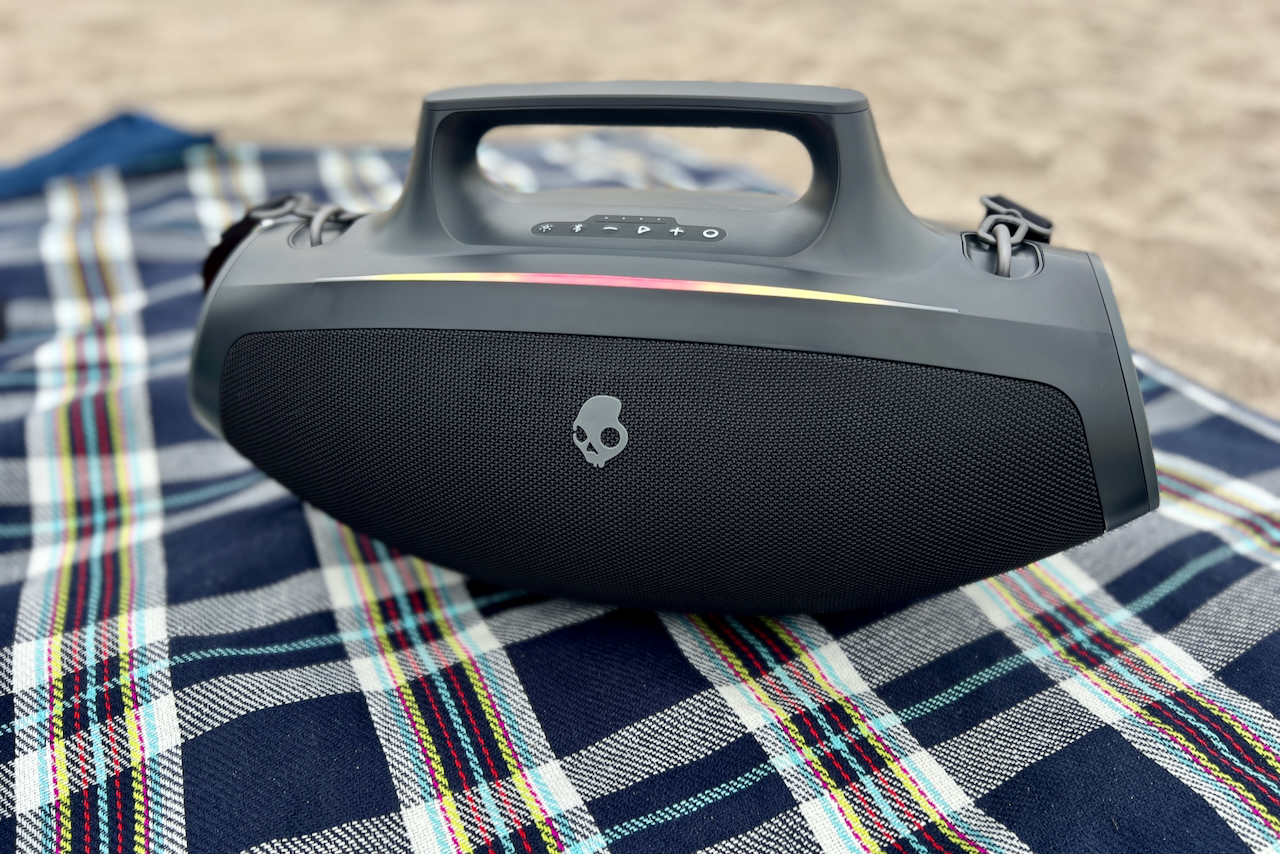 O alto-falante Bluetooth Skullcandy Barrel em um cobertor de praia xadrez.