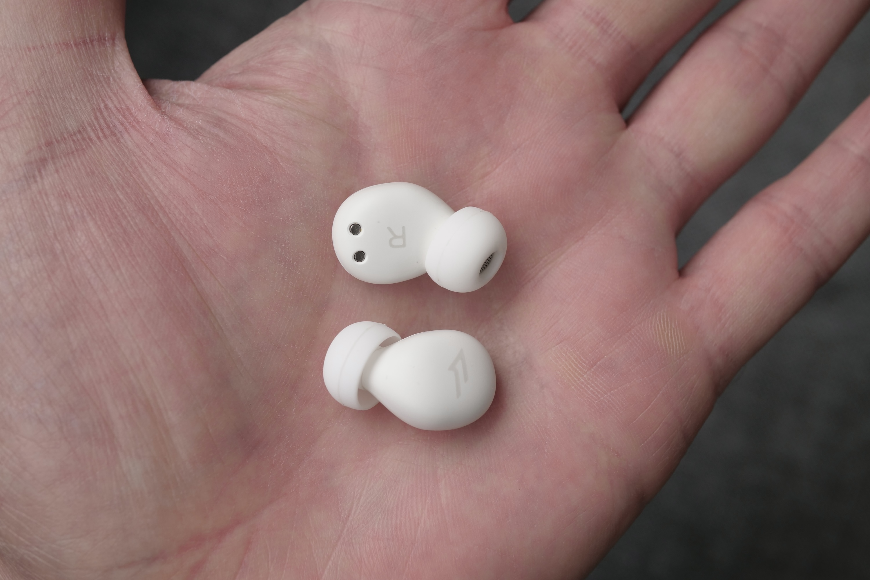 The 1More Z30 Sleeping Earbuds's in a person's palm.