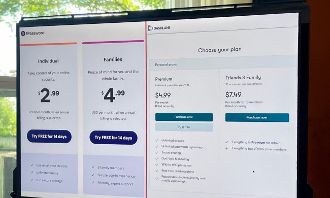 A side-by-side comparison of Dashlane and 1Password pricing appears on a PC monitor.