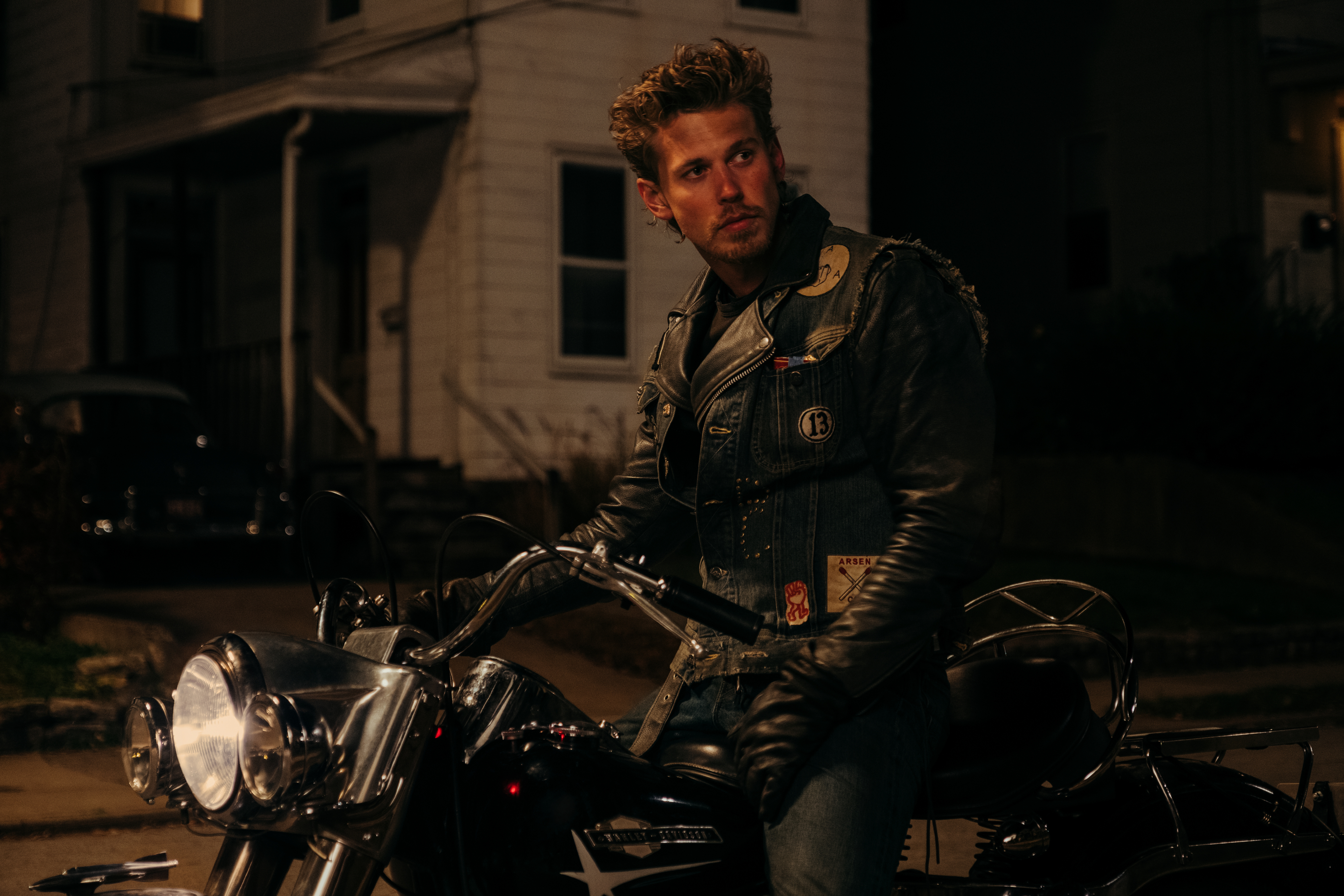 Austin Butler est assis sur une moto la nuit dans The Bikeriders.