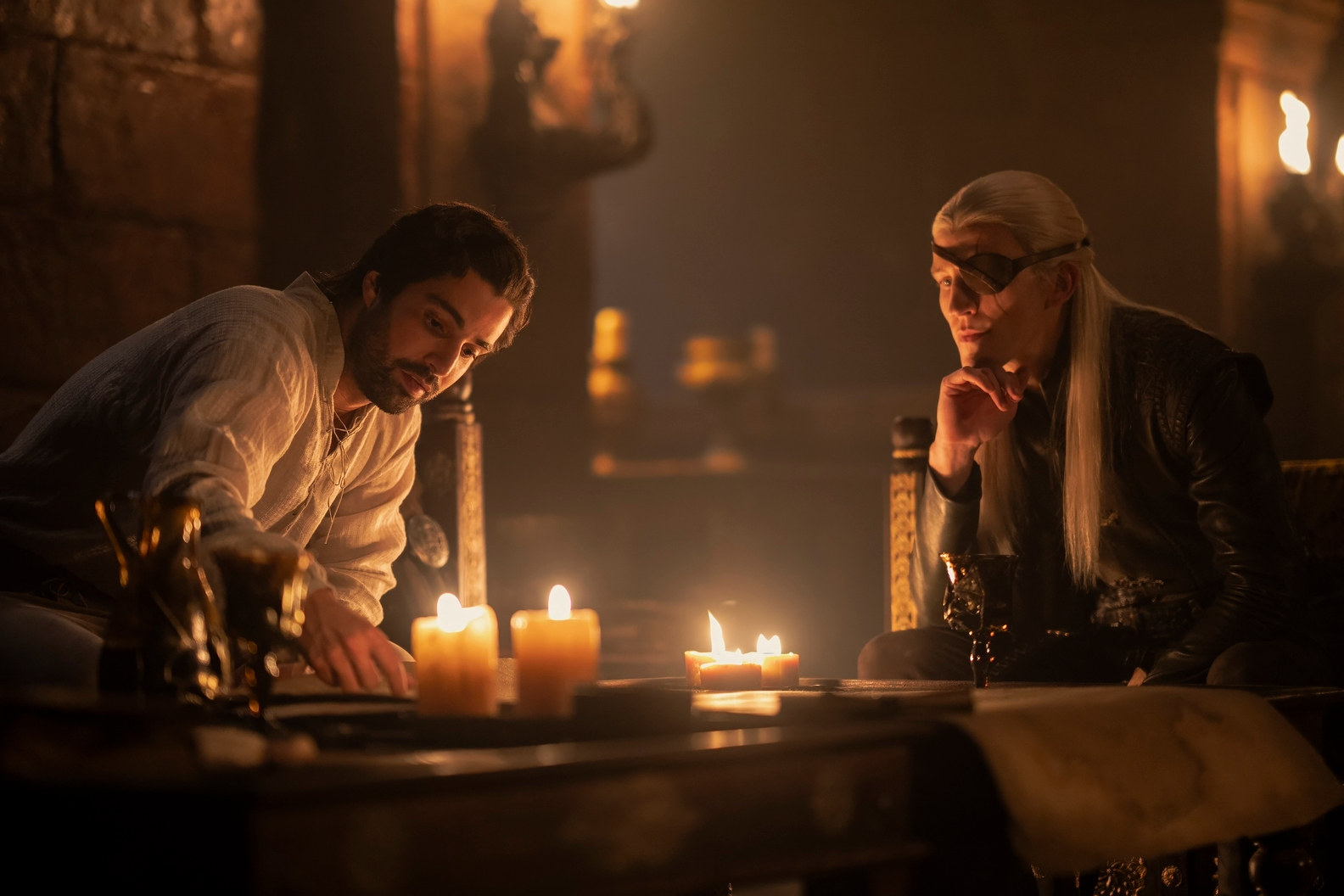 Criston Cole e Aemond Targaryen sentam-se juntos na 2ª temporada de House of the Dragon.