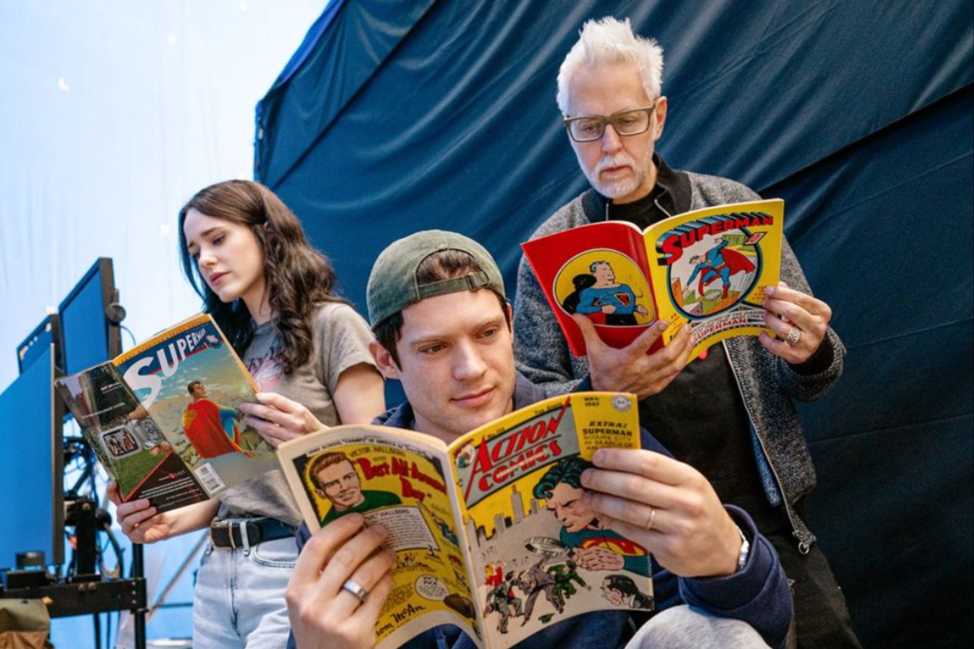 Una mujer y dos hombres leen cómics de Superman.