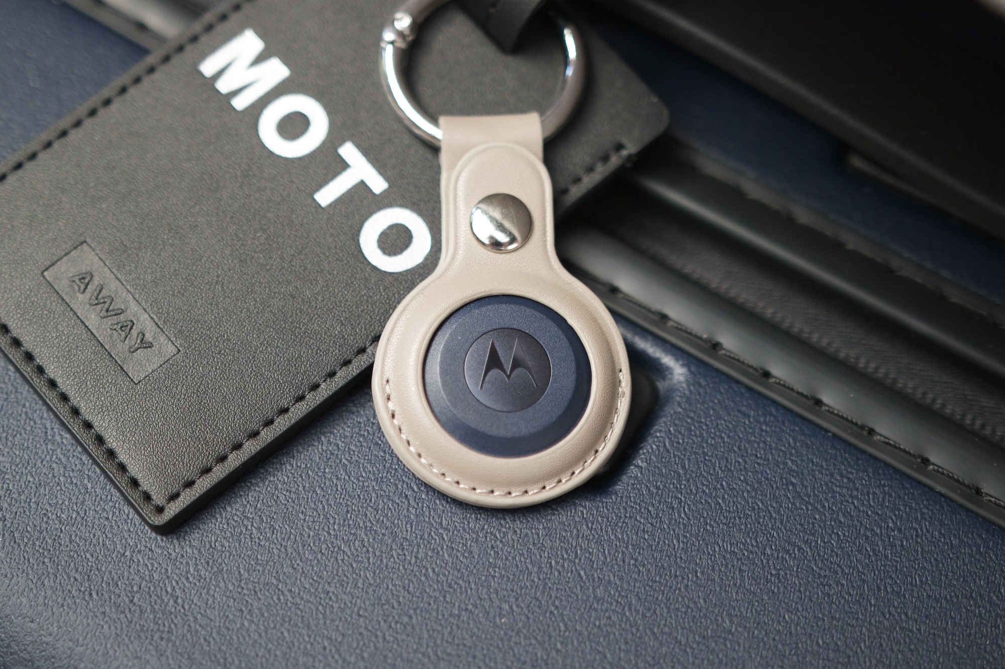 The Moto Tag attached to a suitcase.