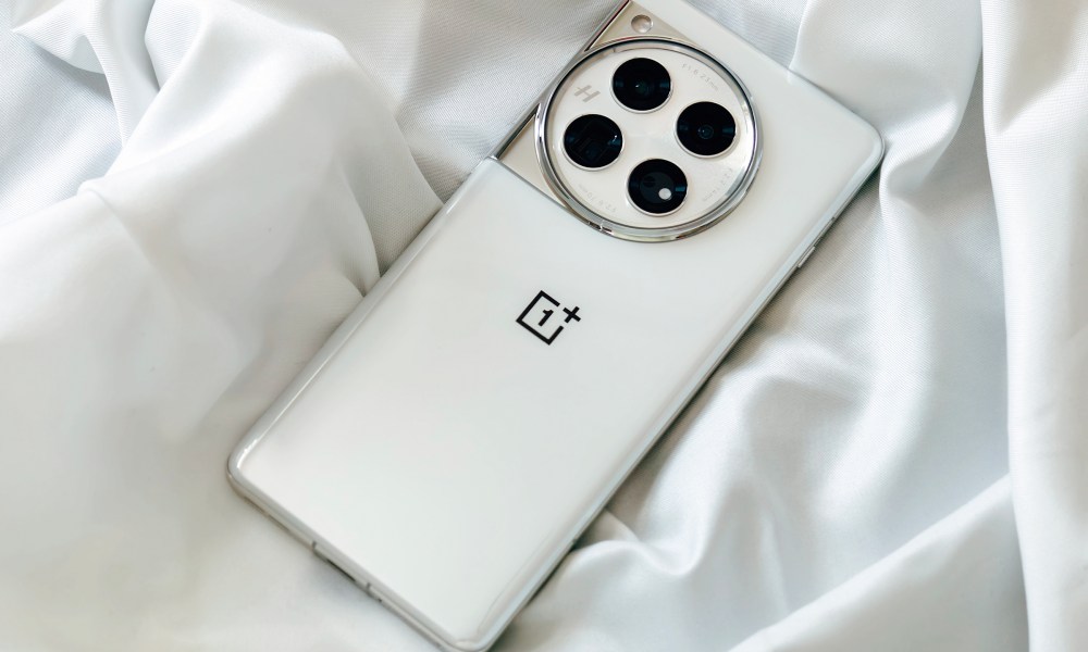 OnePlus 12 Glacial White on a wrinkly satin white cloth.