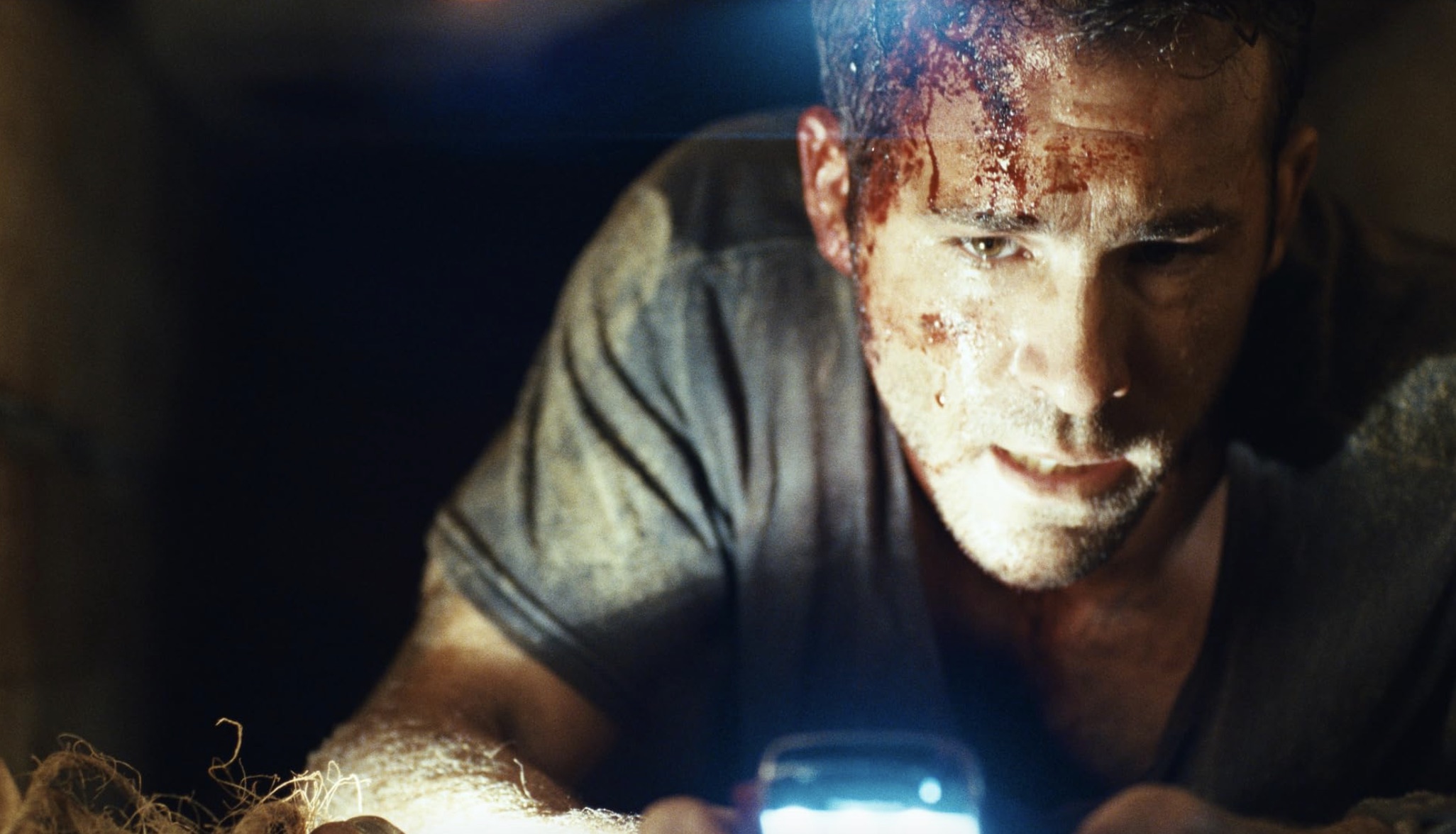 Un hombre sangrando por la cabeza sostiene un teléfono para encenderse.